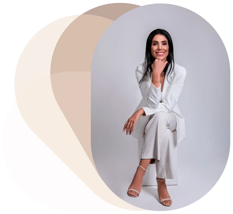 Dra. Amani sentada, com blazer e calça brancos
